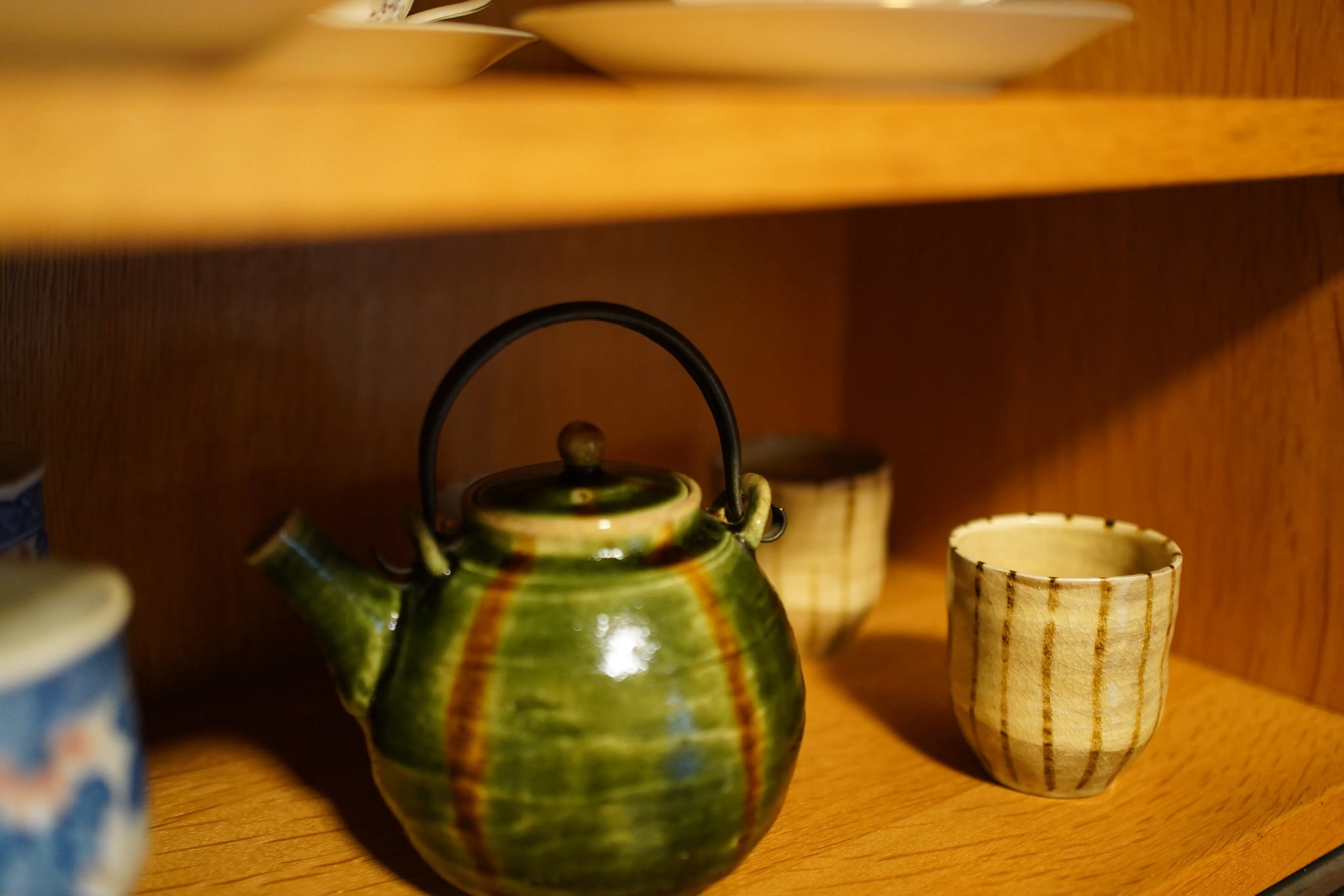 A green-glazed teapot. Only the rattan handle was repaired.